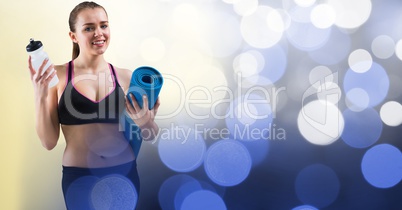 Fit woman holding yoga mat and water bottle
