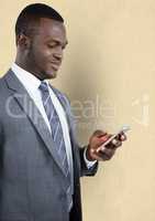 Businessman using smart phone against beige background