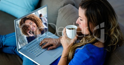 Young woman video conferencing on laptop while having coffee