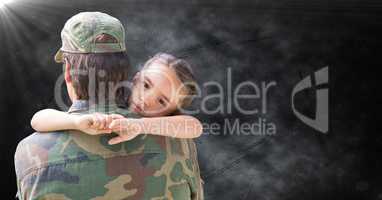 Back of soldier with daughter against black grunge background with flare