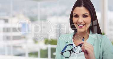Smiling businesswoman holding eyeglasses in office