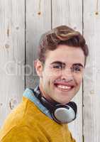 Young man with headphones over wooden wall