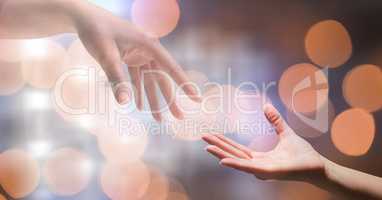 Close-up of woman's hand reaching man against bokeh