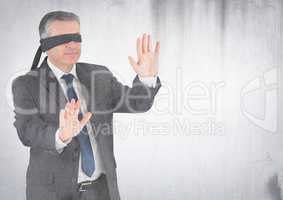 Business man blindfolded with grunge overlay against white wall