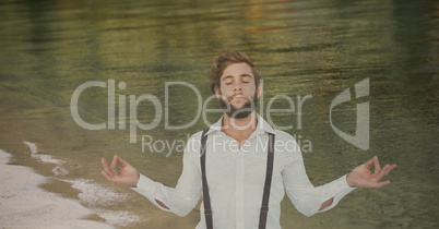 Double exposure of hipster meditating at shore