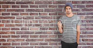 Male hipster holding smoking pipe against wall
