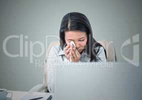 Woman crying at computer against light blue background