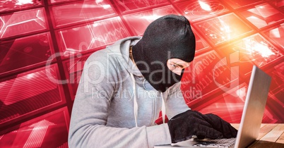 Hacker wearing monkey cap while using laptop