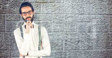 Confident hipster with hand on chin against wall