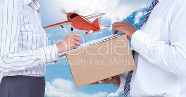 Midsection of delivery man taking sign of woman while delivering parcel with airplane in background