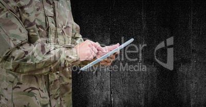 Soldier mid section with tablet against black wood panel