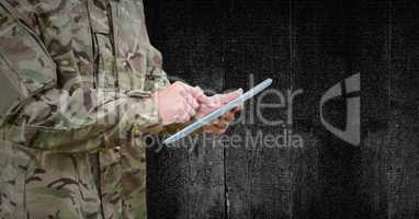 Soldier mid section with tablet against black wood panel