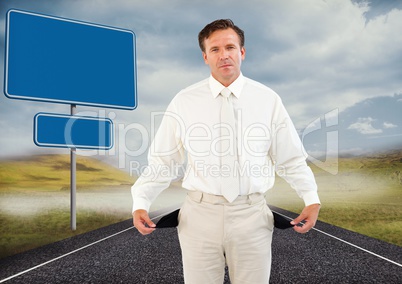 Businessman with empty pockets on road by blank signs