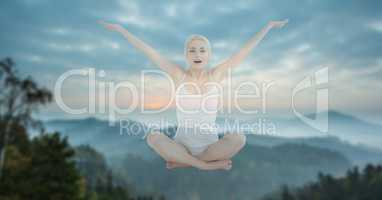 Double exposure of woman performing yoga in midair against mountains