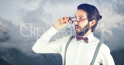 Shocked hipster wearing eyeglasses against mountains