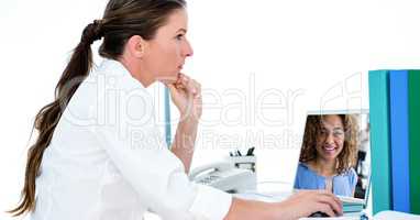 Woman video conferencing with colleague on laptop