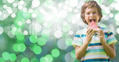 Boy eating watermelon over bokeh