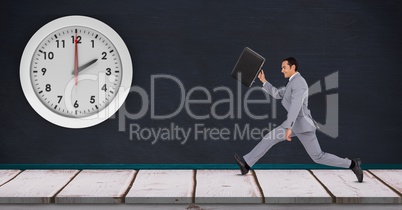 Businessman running late with clock mounted on wall