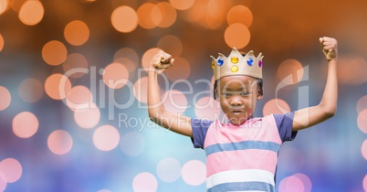Portrait of kid wearing crown while flexing muscles