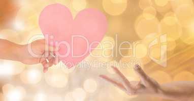 Cropped image of woman giving heart shape to man against bokeh