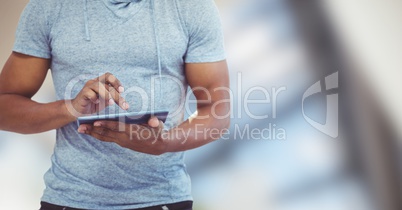 Midsection of man using digital tablet against blurred background
