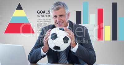 Businessman holding soccer ball against graphs