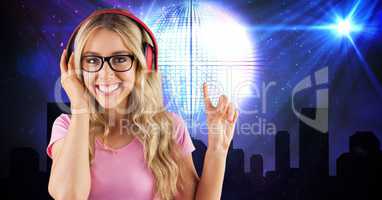 Happy woman pointing while listening to music on headphones