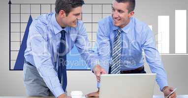 Smiling businessmen using laptop against graph