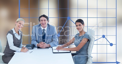 Happy business people at desk against graph