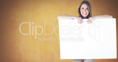 Portrait of woman holding blank billboard against yellow background