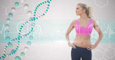 Fit young woman with hands on hips looking at DNA structure