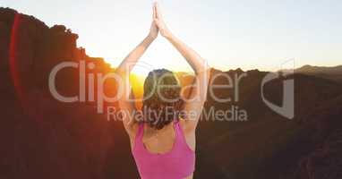 Double exposure of woman with hands clasped performing yoga on mountains
