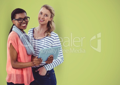 Casual businesswomen with digital tablet over green background