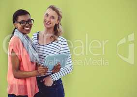 Casual businesswomen with digital tablet over green background