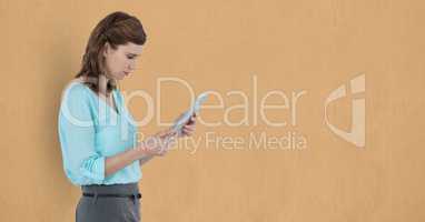 Businesswoman using tablet PC over beige background