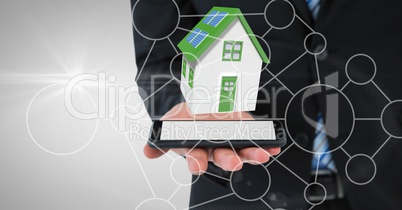 Midsection of businessman with house on device