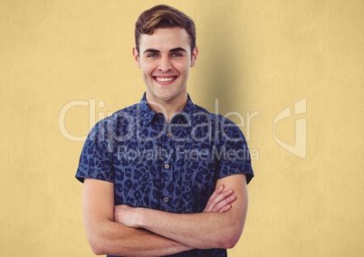 Portrait of happy male hipster standing arms crossed against yellow background