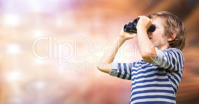 Boy looking through binoculars over blur background