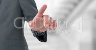 Midsection of businesswoman touching imaginary screen over blurred background