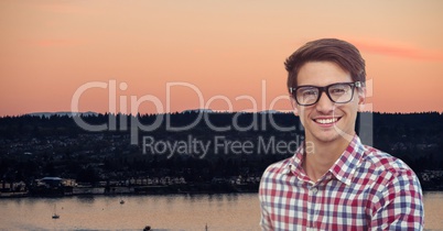 Smiling hipster wearing eyeglasses against landscape