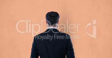 Rear view of businessman over orange background