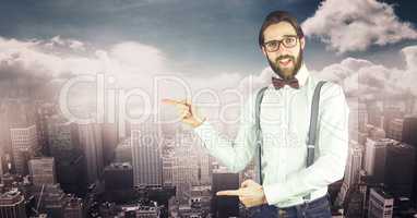 Male hipster pointing against cityscape