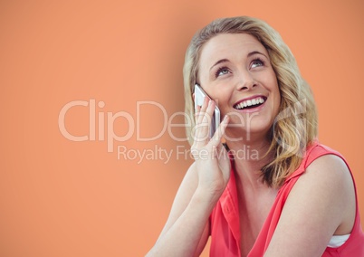 Happy woman using smart phone against orange background