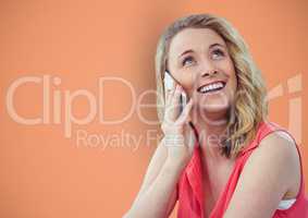Happy woman using smart phone against orange background