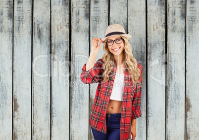 Portrait of confident female hipster standing against wooden wall