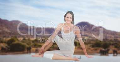 Young woman performing yoga with mountains in background