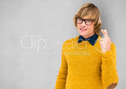 Male hipster in yellow sweater crossing fingers over gray background