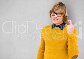 Male hipster in yellow sweater crossing fingers over gray background
