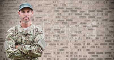 Soldier arms folded against brown brick wall