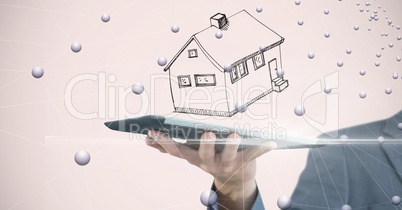 Business person with house over tablet PC surrounded by drops